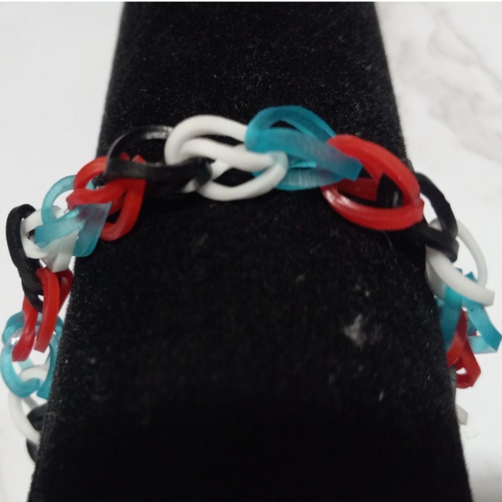 This is a harlequin loom band bracelet the colors are red,black,white,and blue